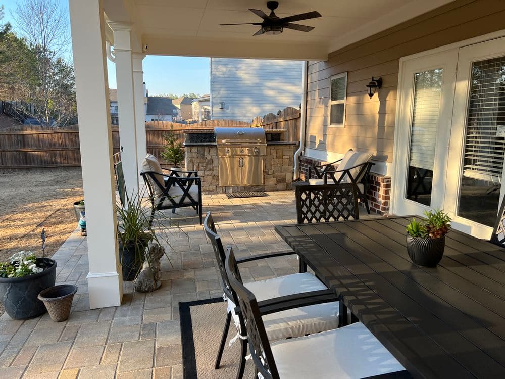 Outdoor patio with a grill, seating area, and potted plants, perfect for entertaining.
